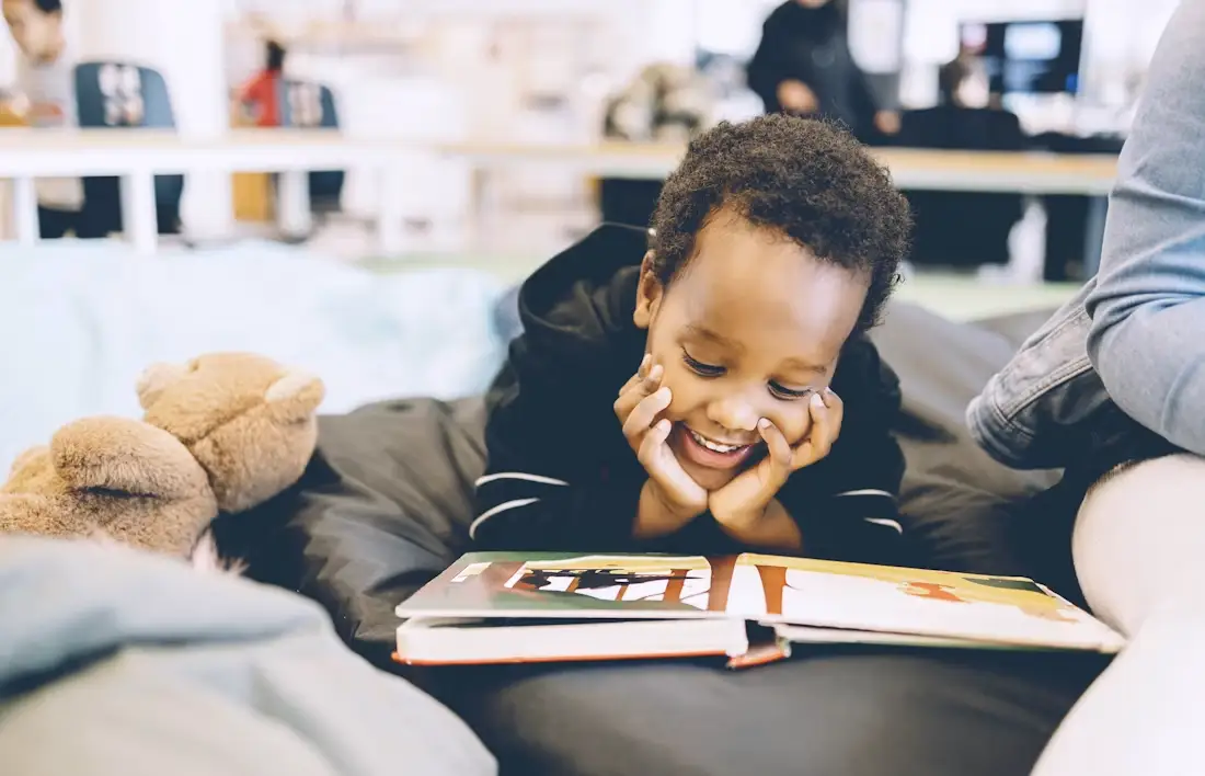 Niño alegre leyendo un libro